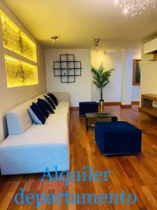 a living room with a white couch and blue pillows at No está disponible in Arequipa