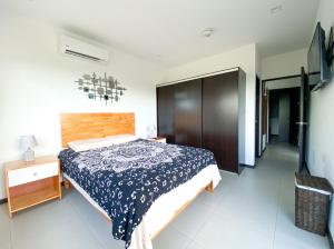 1 dormitorio con 1 cama con colcha azul y blanca en Vistas de Bejuco, en Esterillos Este