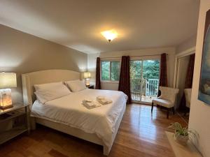 North Nanaimo Gem - Garden-View Room with Private Ensuite في نانايمو: غرفة نوم بسرير ابيض وشرفة