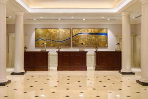 a lobby with columns and a painting on the wall at The College Green Dublin Hotel, Autograph Collection in Dublin