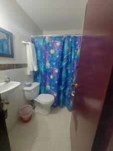 a bathroom with a toilet and a shower curtain at Hotel Rosandy Galaxy in Cartagena de Indias