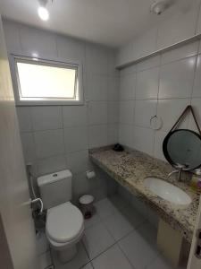uma casa de banho com um WC, um lavatório e uma janela em Verano Apart Ponta Negra em Natal