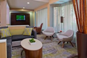 a living room with a couch and chairs and a tv at Courtyard Orlando International Drive/Convention Center in Orlando