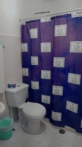 La salle de bains est pourvue de toilettes et d'un rideau de douche violet. dans l'établissement Hotel Rosandy Galaxy, à Carthagène des Indes