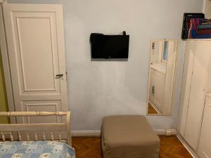 1 dormitorio con 1 cama y TV en la pared en Quartos em Copacabana, en Río de Janeiro