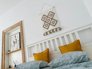 1 dormitorio con cama con almohadas y espejo en Cozy Apartments and Rooms Katowice en Katowice
