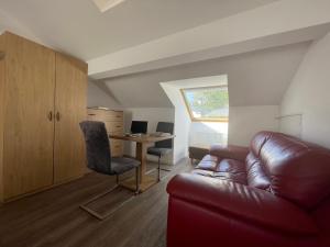 a living room with a leather couch and a desk at Eurotel am Main in Offenbach