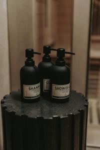 deux bouteilles de shampoing assises sur un récipient noir dans l'établissement MIRA Earth Studios, à San Antonio de las Minas