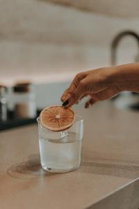 a person is putting a piece of grapefruit into a glass of water at MIRA Earth Studios in San Antonio de las Minas