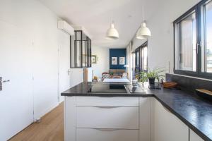 a kitchen with a sink and a counter top at La terrasse d'Issy - Welkeys in Issy-les-Moulineaux