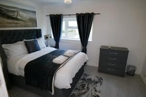 a bedroom with a large bed and a window at Giomakay luxury Rooms Milton Keynes in Milton Keynes