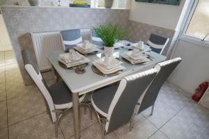 mesa de comedor y sillas con mesa y planta en Giomakay luxury Rooms Milton Keynes en Milton Keynes