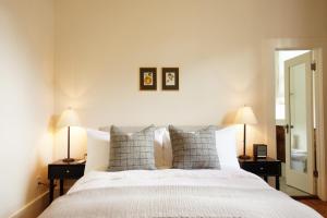 a bedroom with a large white bed with two lamps at Imperial Hotel + Restaurant in Amador City