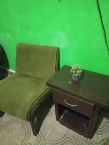 a green room with a chair and a table at Recamara confortable en San Nicolás in Monterrey