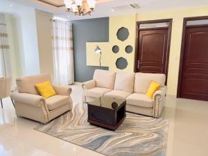 a living room with two couches and a tv at IZA Serene city centre apartments in Kigali