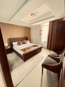 a bedroom with a large bed and a chair at IZA Serene city centre apartments in Kigali