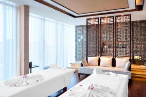 una camera d'albergo con due letti e un divano di Sheraton Langfang Chaobai River Hotel a Dachang