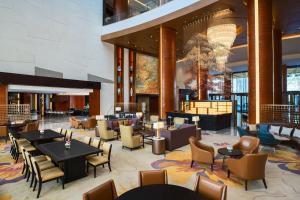 a lobby of a hotel with tables and chairs at Sheraton Beijing Lize Hotel in Beijing