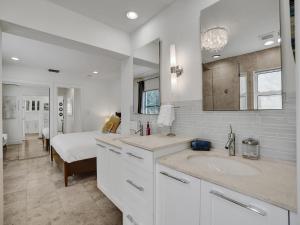a white bathroom with two sinks and a bed at 10 Mins to South Beach Miami 4 Bedroom Villa in Miami