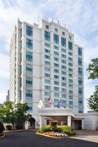 a large white building with two american flags in front of it at Marriott Philadelphia West in West Conshohocken