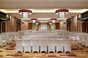 una sala vuota con sedie bianche in una stanza di Four Points By Sheraton Beijing, Haidian a Pechino