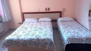 Duas camas sentadas uma ao lado da outra num quarto em Hotel Fenix Salvador em Salvador