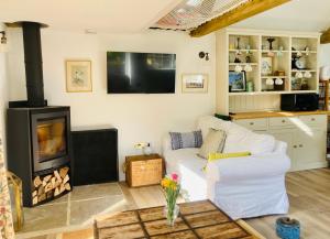 a living room with a white couch and a fireplace at The Old Workshop, Wadhurst in Wadhurst