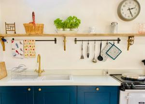 a kitchen with blue cabinets and a sink at The Old Workshop, Wadhurst in Wadhurst