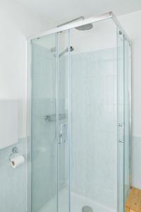 una doccia con porta in vetro in bagno di Apartment Il Nocciolo a Livigno