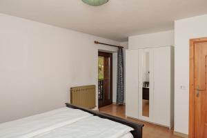 a bedroom with a bed and a door to a kitchen at Apartment Il Nocciolo in Livigno