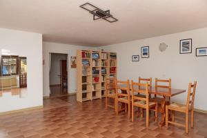 una sala da pranzo con tavolo, sedie e librerie di Apartment Il Nocciolo a Livigno