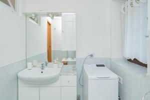 a white bathroom with a sink and a mirror at Apartment Il Nocciolo in Livigno