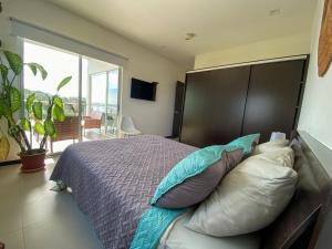 een slaapkamer met een bed met een groot hoofdeinde en kussens bij BEACHFRONT APARTMENT Vistas de Bejuco in Parrita