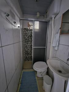a small bathroom with a toilet and a sink at Aconchego Lar Cama e Café in Foz do Iguaçu +62 photos