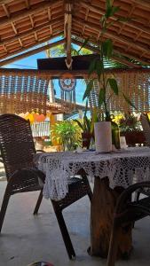 ein Tisch mit einem weißen Tischtuch auf einem Baumstumpf in der Unterkunft ITAÚNAS Pousada Nossa Palhoça in Itaúnas
