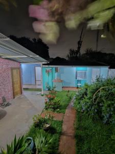 una pequeña casa azul con un patio por la noche en Aconchego Lar Cama e Café, en Foz do Iguaçu