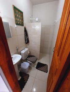 La petite salle de bains est pourvue de toilettes et d'un lavabo. dans l'établissement ITAÚNAS Pousada Nossa Palhoça, à Itaúnas