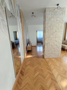 a living room with a wooden floor and a large mirror at High T in Kraljevo