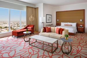 a hotel room with a bed and a couch and chair at Marriott Hotel Downtown Abu Dhabi in Abu Dhabi