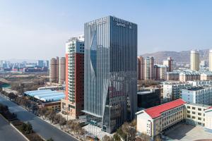 un grand bâtiment en verre dans une ville avec des bâtiments dans l'établissement Fairfield by Marriott Xining North, à Xining