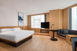 a bedroom with a bed and a couch and a television at Fairfield by Marriott Xining North in Xining