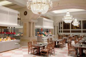 a restaurant with tables and chairs and chandeliers at Delta Hotels by Marriott Shanghai Baoshan in Baoshan