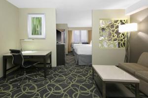 オクラホマシティにあるSpringHill Suites by Marriott Oklahoma City Quail Springsのベッド、ソファ、デスクが備わるホテルルームです。