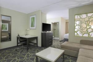 a hotel room with a couch and a desk with a television at SpringHill Suites by Marriott Oklahoma City Quail Springs in Oklahoma City