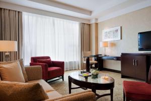 a hotel room with a living area with furniture and a television at Courtyard by Marriott Hangzhou Wulin in Hangzhou