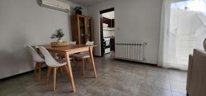 a dining room with a table and white chairs at CABRAL CENTRO in Rafaela