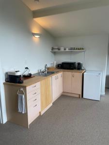 a kitchen with a sink and a refrigerator at Kaingarua Retreat in Kerikeri
