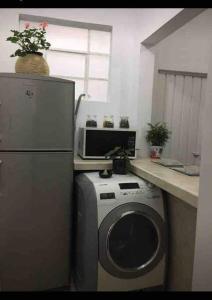 een keuken met een wasmachine en een magnetron bij Cómoda y linda habitación cerca del WTC in Mexico-Stad