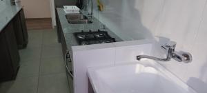 uma cozinha com um lavatório e um fogão em Hermoso departamento em Iquique