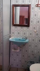 uma casa de banho com um lavatório azul e um espelho. em Hotel Fenix Salvador em Salvador